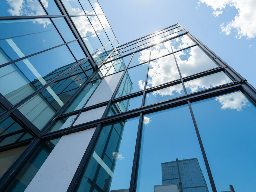 现代化办公楼外观，玻璃幕墙建筑，绿植环绕，蓝天白云背景，专业建筑摄影